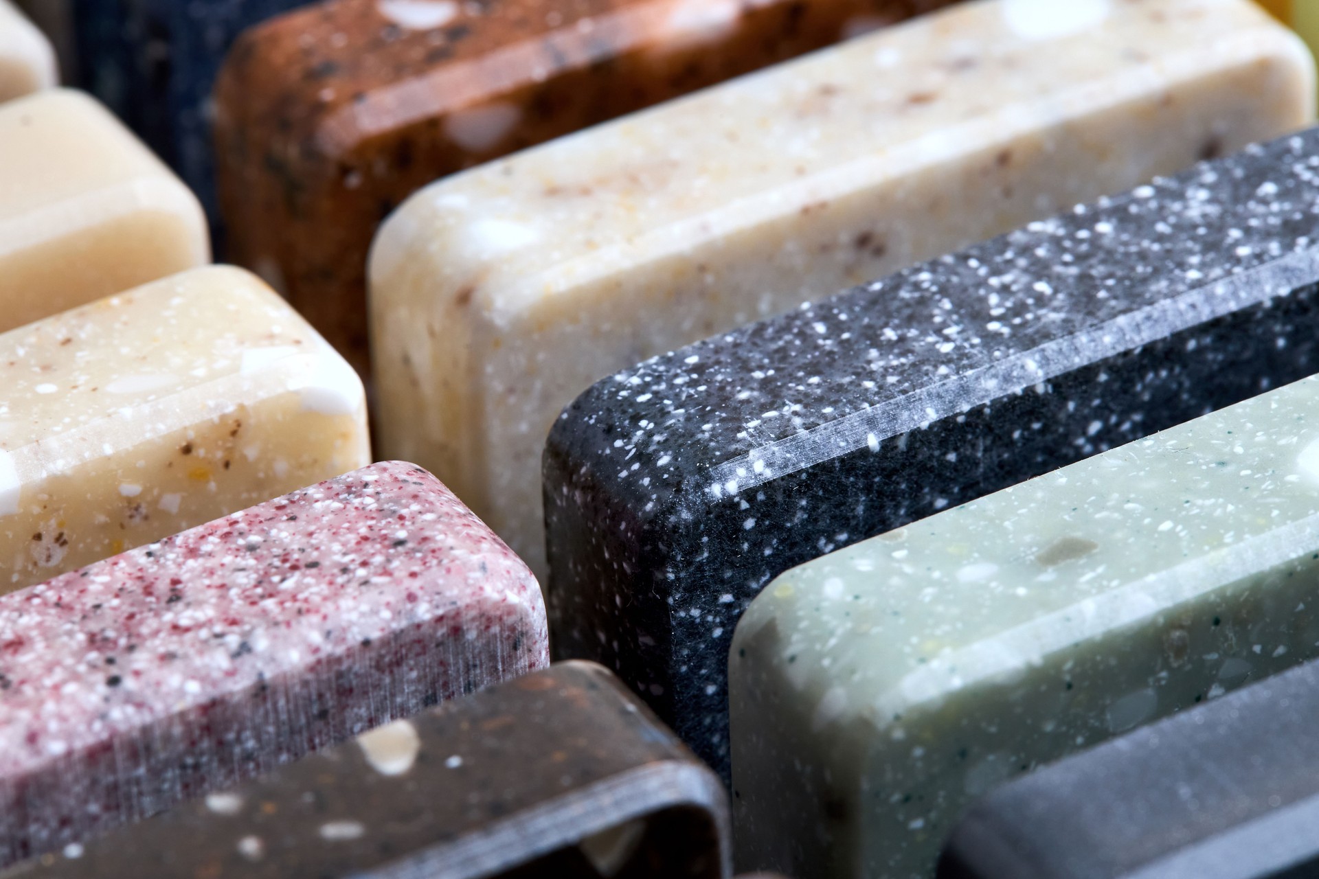 Porcelain stoneware artificial stone square samples as kitchen countertop examples of future kitchen fasade exterior. Samples slabs of natural granite marble quartz for stone countertops close up.